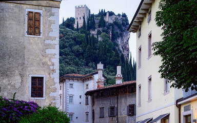 Fototapeta na wymiar Street with Castello di Arco on rock at Garda lake