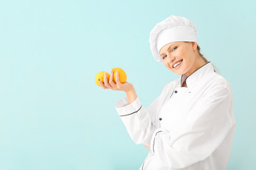 Beautiful female chef with lemons on light background