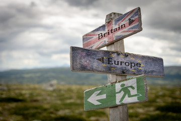 Britain, europe and exit text with flag on wooden signpost outdoors in nature, emergency sign to symbolize Brexit..Politics and country concept.