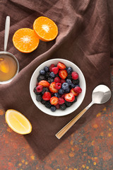 Bowl with tasty fruit salad on color background © Pixel-Shot