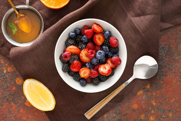 Bowl with tasty fruit salad on color background