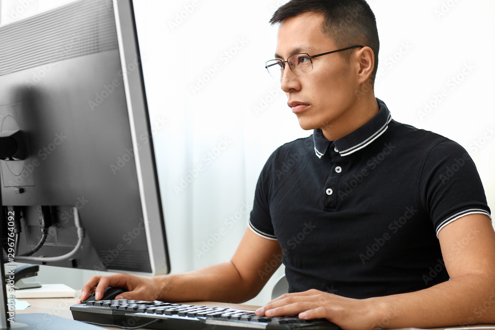 Poster asian programmer working on computer in office