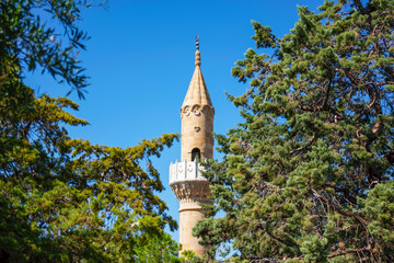 Obraz premium Minaret of a Muslim mosque on a background of blue sky. Religious Muslim temple. Bodrum Turkey.
