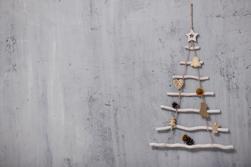 artificial christmas tree and copy space over grey concrete wall