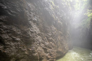Rock wall beside small river with sunlight in Aare gorge (Aareschlucht), Meiringen, Switzerland