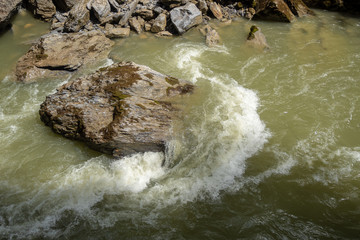 Stone in river with water steam flowing for background and wallpaper