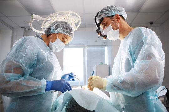 The surgeon, the dentist and the nurse, perform an operation on the patient. The concept of maintaining health and beauty.
