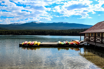 Boats on a dock near the boathouse - colorful kayak and canoes