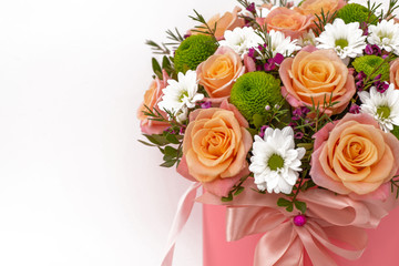 Obraz na płótnie Canvas Beautiful bouquet in a coral luxury present box with a pink bow, isolated on white background