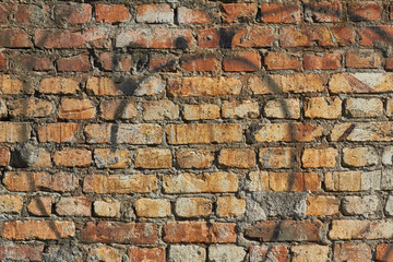red brick wall texture, traces of black paint on the wall