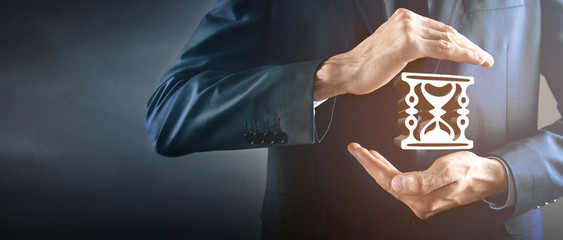 The man holds a clock in hands
