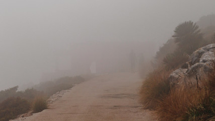 landscape of a house with people totally covered with fog