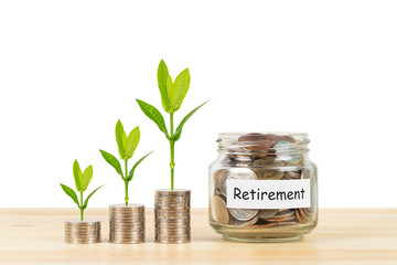 Coin glass jar container and stack on wooden desk with tree leaves growing, on white background, retirement saving concept