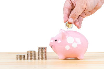 Piggy bank and coin stack with hand putting money, on white background, saving concept