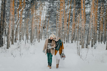 The bride and groom in a snowy forest in winter. Winter wedding.