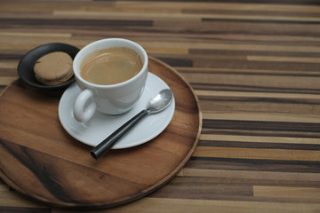 A white cup of coffee with sweet dessert in a vintage coffee house