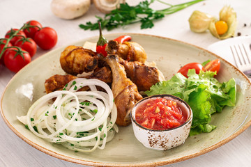 Fried chicken leg with tomato sauce and mixed salad in a serving dish. Copyspace