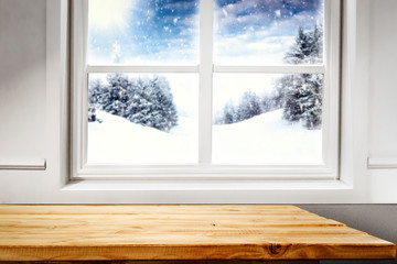 Table background of free space and blurred winter window 