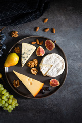 Various kinds of cheese served on wooden board, traditional pieces of french and italy hand-made cheese. Delicacy, dairy products, healthy nutrition, keto diet