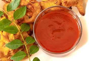 Onion Pakora with Chutney served in plate bowl.