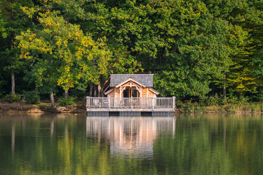 une maison sur pilotis sur un lac avec une for&ecirc;t. Une maison &eacute;cologique en bois sur l'eau. 