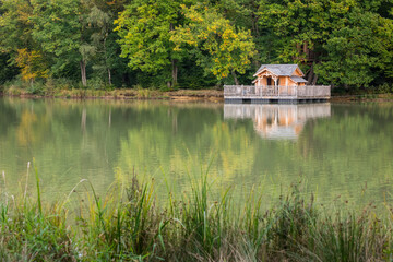 Obraz premium une maison en bois écologique sur pilotis au bord d'un lac. Une cabane en bois vers un lac et une forêt. 