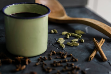 Mulled wine in a vintage cup, wooden spoon and spice