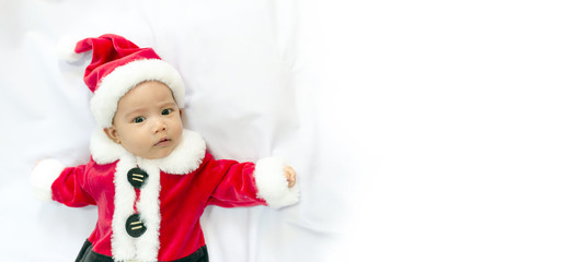 little baby wearing red Santa Claus costume sleep on white fur carpet. Concept of celebrates Christmas and New Year's holidays. with copy space for text.