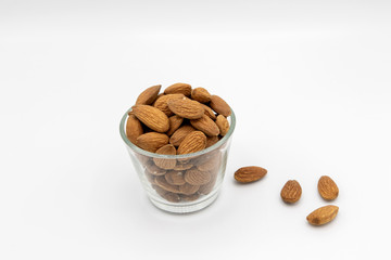 almonds in a bowl and on white background