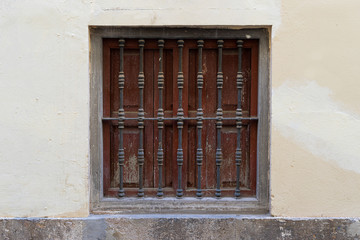 Vintage window with iron grating on a stone wall. Valencia, Spain