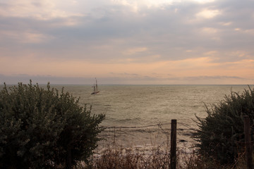 un voilier sur la mer au coucher de soleil. romantisme au bord de mer. Un bateau voguant sur les flots.