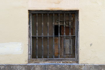 Fototapeta na wymiar Vintage window with iron grating on a stone wall. Valencia, Spain