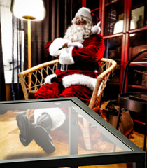 Fototapeta na wymiar Glass coffee table of free space for your decoration and red old Santa Claus in home interior 