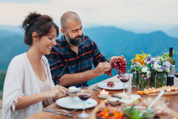 Friends and family gathered for picnic dinner for Thanksgiving. Festive young people celebrating...