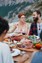 Friends and family gathered for picnic dinner for Thanksgiving. Festive young people celebrating...