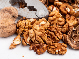 Chopped walnuts with kernels on a gray surface.
