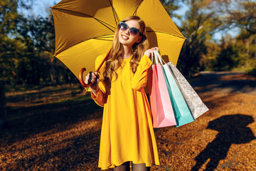 Beautiful stylish young woman, in autumn clothes, with bags after shopping