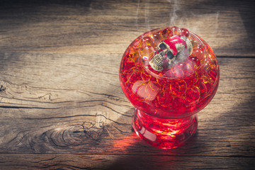 Halloween welcome drink with skull and hot transparent ball on old wooden table