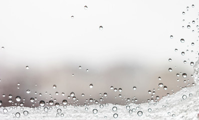 Drops of water and snow on the window. Fall frosts.
