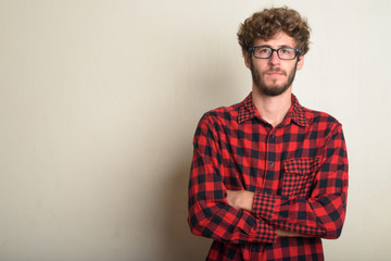 Young bearded hipster man wearing eyeglasses with arms crossed