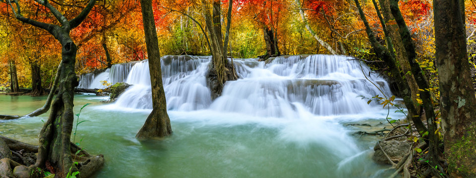 Colorful majestic waterfall in national park forest during autumn, panorama - Image © wirojsid