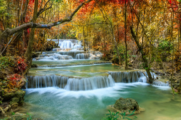 Beautiful and colorful waterfall in deep forest during idyllic autumn