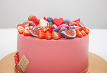 Close up pink cake decorated berries and fruits and chocolate