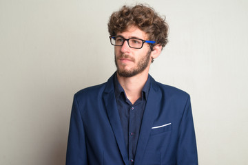 Face of young bearded businessman with eyeglasses thinking