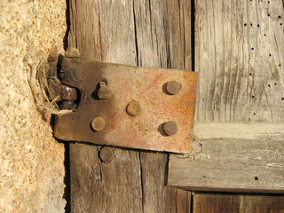 Ferragem com ferrugem de portão e/ou porta de madeira.