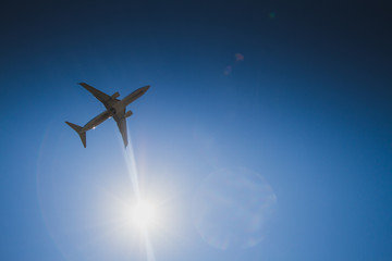 airplane in the sky with clouds and sun