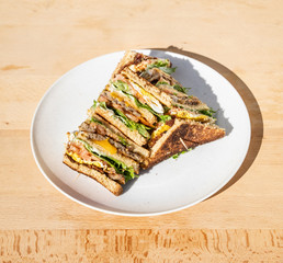 Breakfast cheeseburger with beef, cheese, egg, lettuce, and tomato. A breakfast sandwich for brunch.