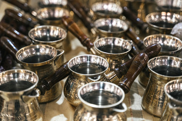 Turkish copper coffee pots with ornaments on a counter in a Turkish bazaar