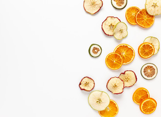 Christmas composition with dried oranges and apples slices on white background. Natural dry food ingredient for cooking or Christmas decor for home. Flat lay.