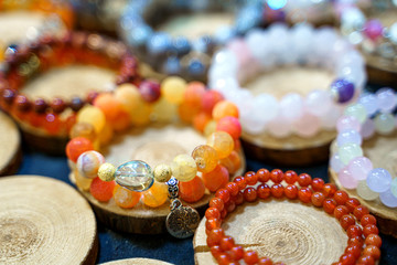 Variety of handmade beautiful stone bracelets on wooden stand
